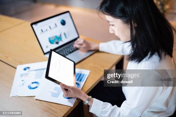 female using digital tablet in office - 財政報告 個照片及圖片檔