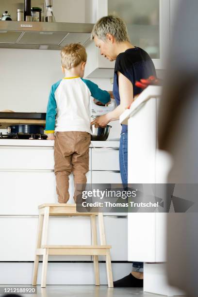 Symbolic picture on the subject of family life: A woman and an infant stand together in the kitchen and bake a cake on May 03, 2020 in Berlin,...