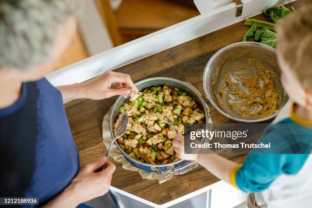 Symbolic picture on the subject of family life: A woman and an infant stand together in the kitchen and bake a cake on May 03, 2020 in Berlin,...