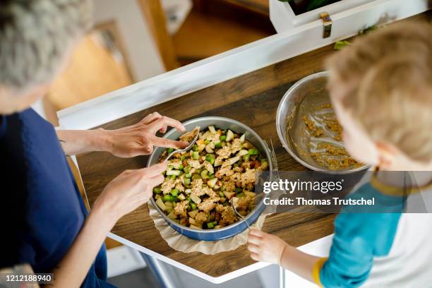 Symbolic picture on the subject of family life: A woman and an infant stand together in the kitchen and bake a cake on May 03, 2020 in Berlin,...