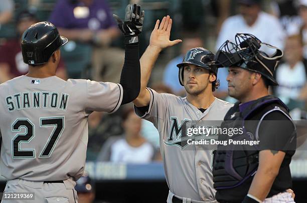 Mike Stanton of the Florida Marlins is welcomed home by Bryan Petersen of the Florida Marlins as they celebrate Stanton's two run homerun off of...