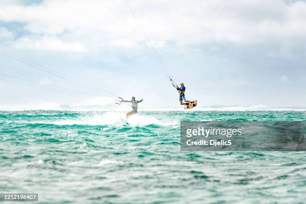 two men kiteboarding together at mauritius island - kite surfing stock pictures, royalty-free photos & images