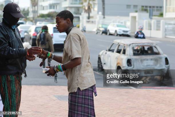 Homeless man gets food at the petrol bombed car of Peter Wagenaar who started feeding the homeless in his affluent neighbourhood of Sea Point during...