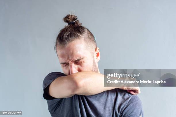 young blond hair caucasian male sneezing on his arm - drawing charcoal stock pictures, royalty-free photos & images