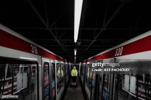 An employee wearing a protective suit disinfects the metro, on May 7 in Venissieux, near Lyon, as the country prepares to ease a two-month...