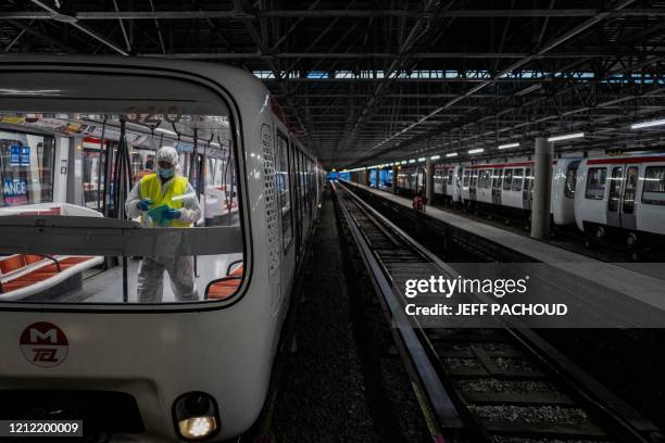 An employee wearing a protective suit disinfects a metro, on May 7 in Venissieux, near Lyon, as the country prepares to ease a two-month coronavirus...