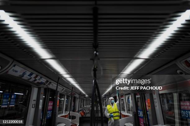 An employee wearing a protective suit disinfects a metro, on May 7 in Venissieux, near Lyon, as the country prepares to ease a two-month coronavirus...