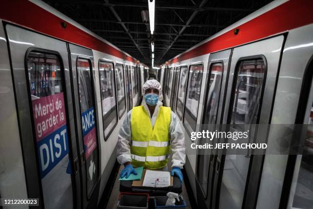 An employee poses wearing a protective suit as he disinfects the metro, on May 7 in Venissieux, near Lyon, as the country prepares to ease a...