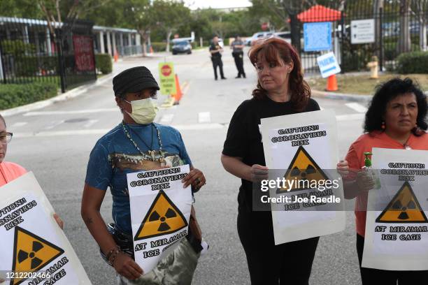 Odalys K. Fernandez, Laurie Woodward Garcia and Yaquelin Lopez hold signs reading, ' Caution!! coronavirus risk at Miramar Ice cage', as they join...