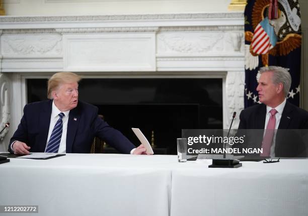 President Donald Trump holds up a note to US representative Kevin McCarthy as he meets with Republican members of the US Congress in the State Dining...