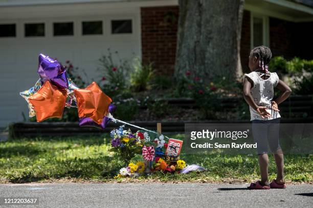 Young girl looks at a memorial for Ahmaud Arbery near where he was shot and killed May 8, 2020 in Brunswick, Georgia. Gregory McMichael and Travis...