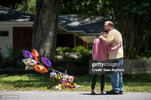 People comfort one another while looking at a memorial for Ahmaud Arbery near where he was shot and killed May 8, 2020 in Brunswick, Georgia. Gregory...