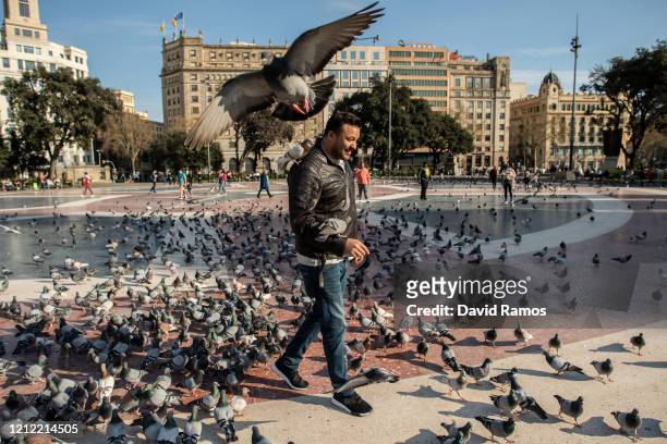 Man walks on a nearly empty tourist spot of Plaza Catalunya on March 13, 2020 in Barcelona, Spain. The number of people confirmed to be infected with...