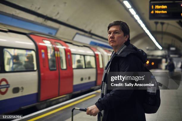 man waiting for a train - london tube photos et images de collection