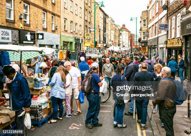 brick lane in london mit käufern beschäftigt - east london london stock-fotos und bilder