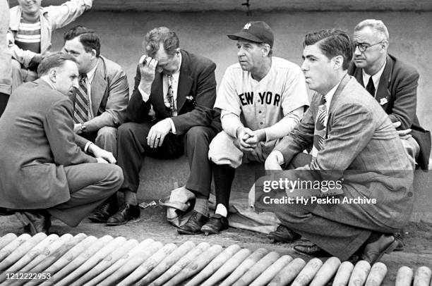 Manager Bucky Harris of the New York Yankees sits on the dugout steps with members of the media prior to an MLB Spring Training game against the...