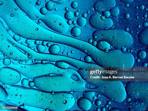 full frame of abstract shapes and textures formed of bubbles and drops oil stains on a blue color liquid background. - blue swirls with bubbles stock pictures, royalty-free photos & images