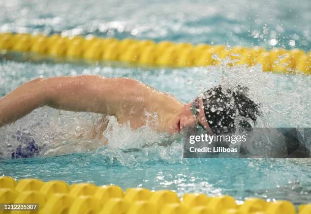 young man swimming freestyle - kids swim caps stock pictures, royalty-free photos & images