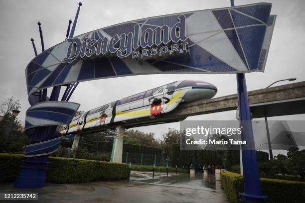 The monorail passes an entrance gate to the famed amusement park Disneyland on March 13, 2020 in Anaheim, California. Walt Disney Co. Is shuttering...