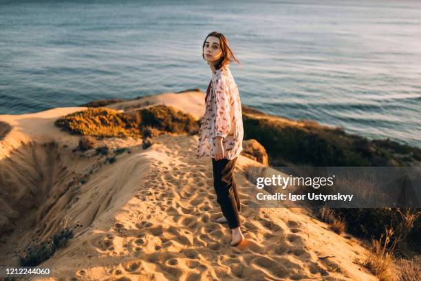 young beautiful woman walking on beach alone - albufeira beach stockfoto's en -beelden