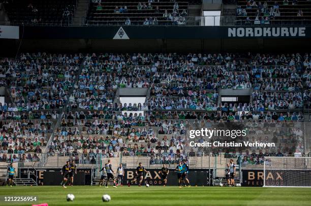 Players in action in front of the 'Pappkameraden' during a training session of Borussia Moenchengladbach at Borussia-Park on May 08, 2020 in...