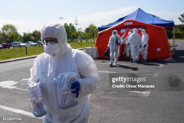 Health worker wears a protective suit, gloves, mask and a face shield as she carries saliva samples from miners to test for COVID-19 at Rybnik...