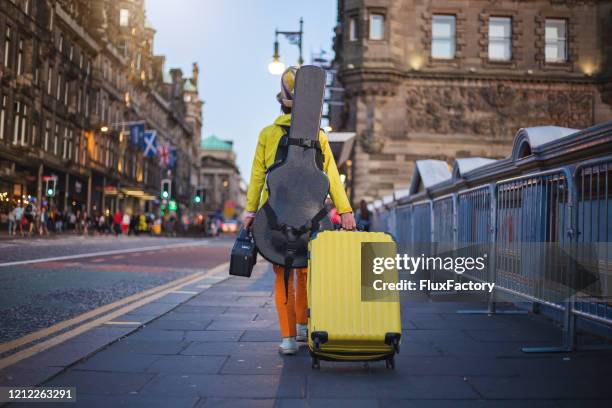 artista callejero que se va después de actuar - guitar fotografías e imágenes de stock