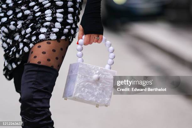 Guest wears a black top with mittens, a sequined asymmetric black gathered mini dress with white polka dots, black plumetis tights, thigh-high boots,...