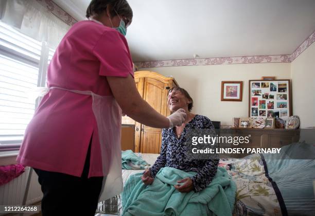Dawn, a carer from Elite Care wears PPE as she tends to her client Tina during a home visit in Scunthorpe, northern England on May 8, 2020. Tina has...