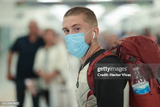 Passenger wears a protective masks after arriving at Mexico City airport on March 13, 2020 in Mexico City, Mexico. Mexican peso, crude oil price and...