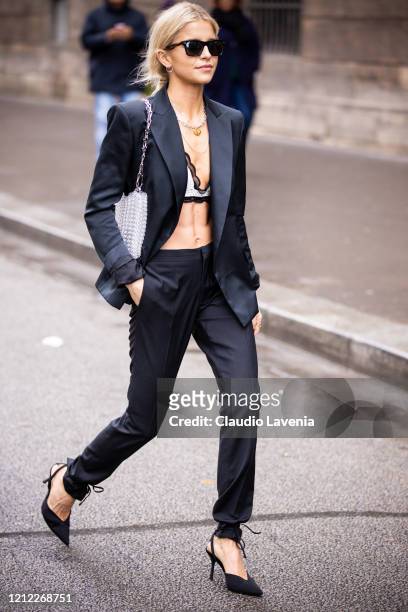 Caroline Daur, wearing a white bralette, black suit, black heels and silver bag, is seen outside Giambattista Valli, during Paris Fashion Week -...