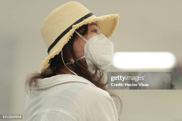 Passenger wearing a protective masks looks on after arriving at Mexico City airport on March 13, 2020 in Mexico City, Mexico. Mexican peso, crude oil...