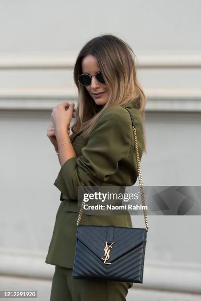 Sarita Holland wears a Cazinc olive green suit and Yves Saint Laurent bag ahead of Runway 1 at Melbourne Fashion Festival on March 11, 2020 in...