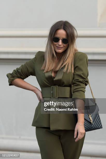 Sarita Holland wears a Cazinc olive green suit and Yves Saint Laurent bag ahead of Runway 1 at Melbourne Fashion Festival on March 11, 2020 in...