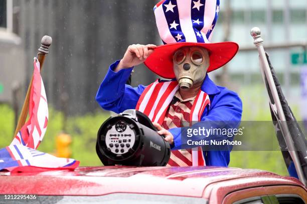 Robert McMaster, of Bridesburg stands on the bed of a pick-up while wearing a mask as he participates in a Reopen protest, at City Hall in...