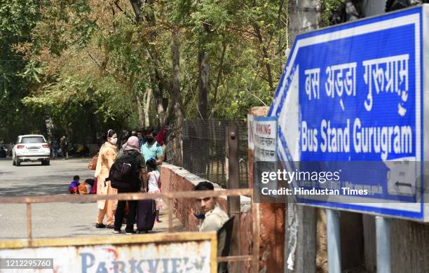 Stranded migrant workers wait for buses bound to their native state Uttarakhand, during lockdown, in Rajiv Nagar, on May 9, 2020 in Gurugram, India....