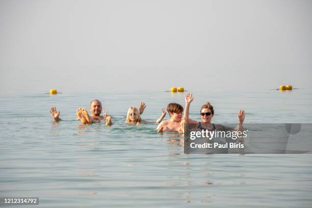happy family taking a bath in the death sea, jordan - bath salt stock-fotos und bilder