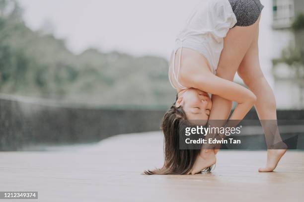 an asian chinese female yoga instructor with standing forward bend - female muscle calves stock pictures, royalty-free photos & images