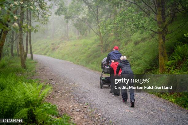 family hiking on an incline through a forest - bergen bildbanksfoton och bilder