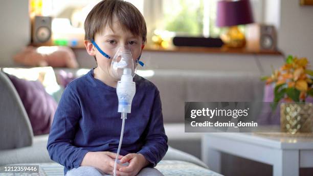 kleiner junge in der inhalationsmaske mit atembeschwerden - respiratory disease stock-fotos und bilder