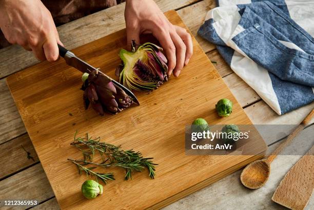 cutting artichoke on a cutting board - artichoke stock pictures, royalty-free photos & images