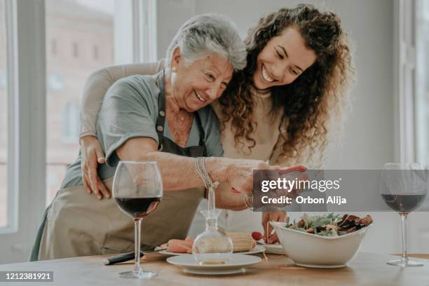 mutter und tochter bereiten einen salat zu - wein und kochen stock-fotos und bilder