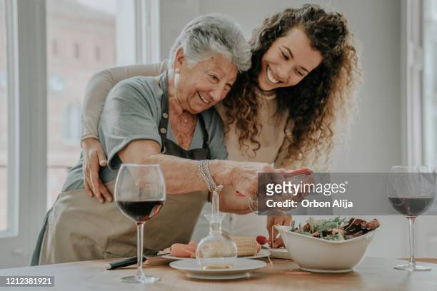 mother and daughter preparing a salad - senior women wine stock pictures, royalty-free photos & images