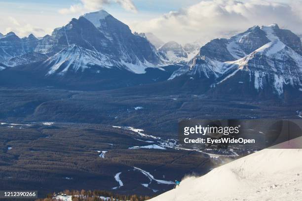 Rocky Mountains, large forests and a skier on a slope on November 19, 2014 in Lake Louise, Canada.
