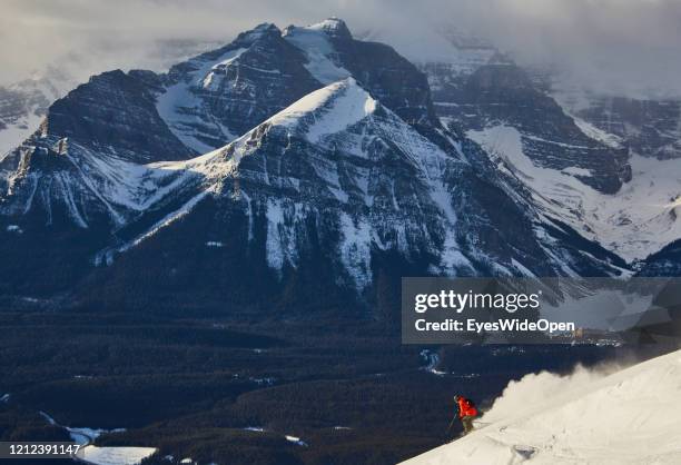Skier on a slope, in the background Hotel Fairmont Chateau with Lake and Glacier on November 19, 2014 in Lake Louise, Canada.