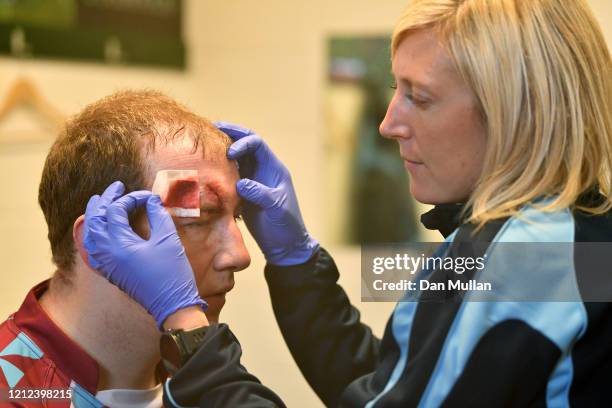 Mylo Connell of OPMs receives treatment to a head injury following the Lockie Cup Semi Final match between Old Plymouthian and Mannameadians and...