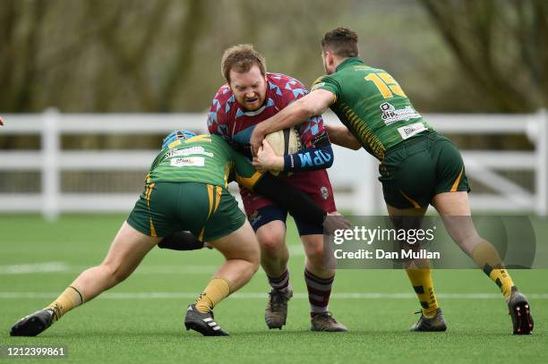 Ben Neville of OPMs is tackled by Alex Broughton and Hayden Coles of Plymstock Albion Oaks during the Lockie Cup Semi Final match between Old...