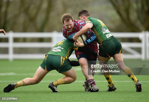 Ben Neville of OPMs is tackled by Alex Broughton and Hayden Coles of Plymstock Albion Oaks during the Lockie Cup Semi Final match between Old...
