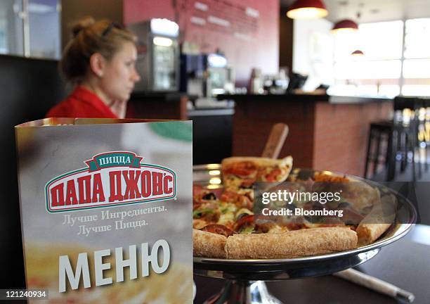 Menu and a pizza sit on a table at a Papa John's International Inc. Pizza restaurant in Moscow, Russia, on Tuesday, Aug. 16, 2011. Domino's, which...