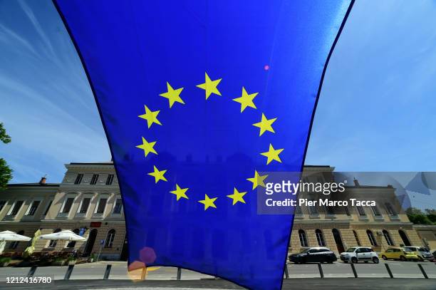 The European Union flag flies on the wire mesh that divides Piazza Transalpina on May 8, 2020 in Gorizia, Italy. Piazza Transalpina is a square...